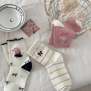Close-up of cute cotton socks featuring bunny embroidery, bows, and ruffled edges