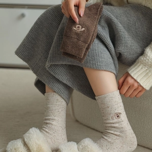Close-up of wool socks with colorful speckle texture and cute dog embroidery detail