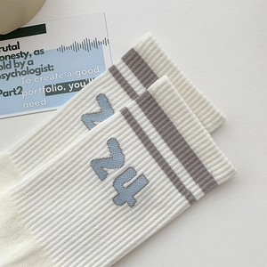 Detail of ribbed crew sock in off-white with grey stripes and blue Z4 letter embroidery