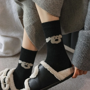 Gros plan détaillé du motif de chien brodé sur des chaussettes en laine noire épaisses