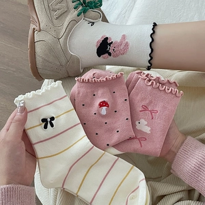 Detail of pink socks featuring cute rabbit embroidery and delicate ruffle cuff trim