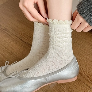 Nahaufnahme weißer Socken mit hohlem Schmetterlingsmuster und Rüschenspitzenbündchen