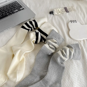 Dettaglio di calze in cotone a costine color crema e grigio con strisce vintage