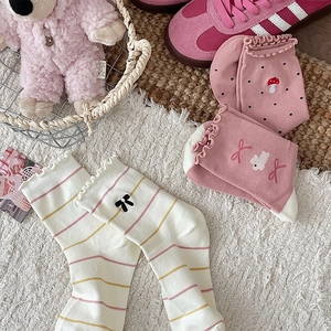 Detail of pink and white socks with bow embroidery, mushroom patterns and ruffle cuff
