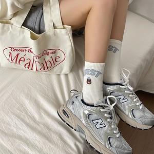Detail of cute bear embroidery and 'BEST' lettering on striped ribbed cotton socks