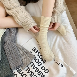Close-up of cable knit wool socks featuring textured ribbing and soft thick thermal fabric