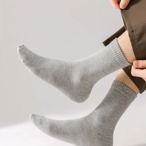 Detail of light grey cotton crew socks featuring a ribbed cuff and fine knit texture
