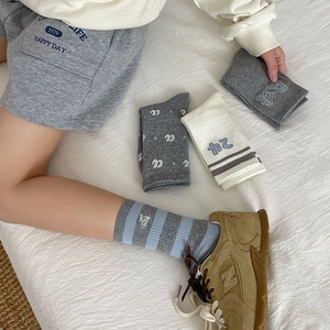 Detailed close-up of knit cotton crew socks featuring cute bear embroidery and stripes