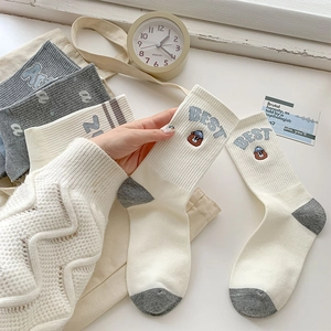 Detail of cotton crew socks with BEST embroidery and cute bear pattern in blue and grey