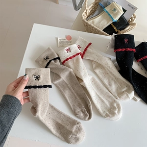 Detailed close-up of ribbed knit socks with ballet bow embroidery and colorful dots
