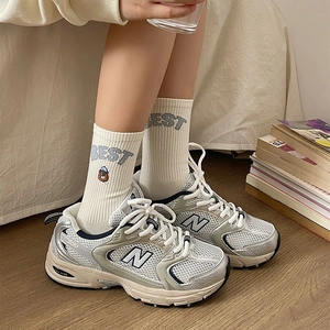 Detailed shot of white ribbed socks featuring bear embroidery and BEST letter patterns