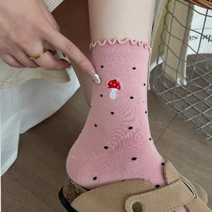 Detailed view of pink knit socks featuring mushroom embroidery and wavy lettuce trim edges
