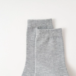 Close-up of light grey mid-calf sock showing ribbed cuff and fine knit cotton texture