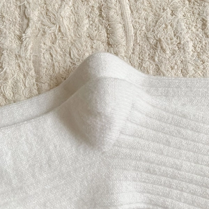 Macro detail of white ribbed wool socks showing premium knit texture and fabric soft finish