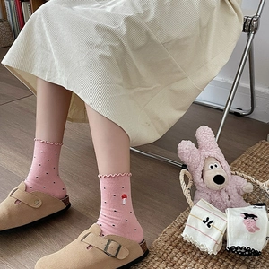 Detailed close-up of cute pink bow socks with mushroom embroidery and ruffle trim