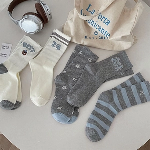 Detail view of cotton mid-calf socks with cute bear embroidery and striped college patterns