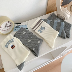 Detail of embroidered college style cotton socks featuring bear motif and stripes