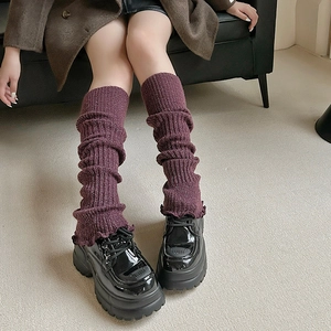 Détail de jambière en maille côtelée prune avec des chaussures compensées noires
