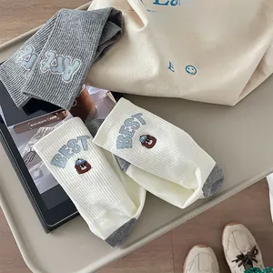 Detail of striped cotton crew socks with cute bear embroidery and varsity lettering