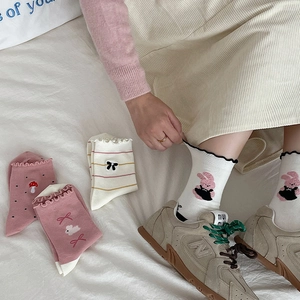 Close-up of sweet bow embroidery and frill edge on pink cotton mid-calf socks