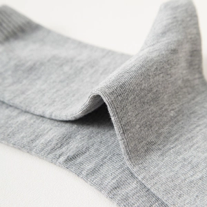 Close-up of grey cotton crew socks showing soft knit texture and ribbed elastic cuff