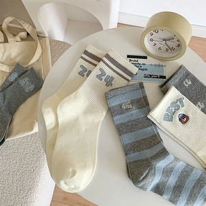 Flat lay of Japanese cartoon crew socks with stripes, numbers and bear embroidery