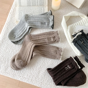 Détail du tricot torsadé et de la broderie nœud sur des chaussettes en laine d'hiver