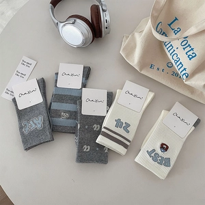 Flat lay of five pairs of cotton socks with bear embroidery and student style patterns