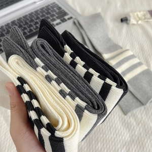 Primo piano di calze in maglia con polsini a righe nei colori bianco, grigio e nero