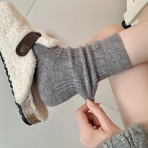 Detail showing elastic grey wool socks with vertical knit pattern and warm texture