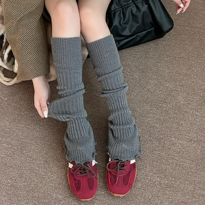 Gros plan de jambières en tricot gris foncé avec fil brillant et texture côtelée