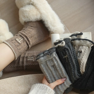 Gros plan détaillé sur la broderie nœud et la maille torsadée des chaussettes