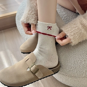 Detail of cream ballet core socks with red bow embroidery and ruffled edge design