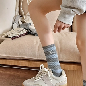 Detail of blue and gray striped crew socks with white RTY embroidery and ribbed cuffs