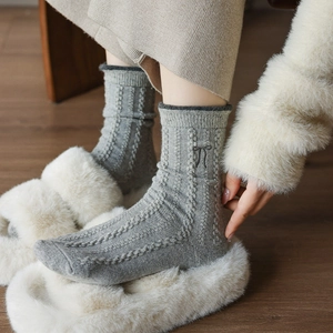 Détail de chaussettes en laine avec broderie nœud et maille torsadée pour l'hiver