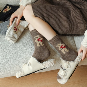Close-up of knitted wool socks with cute bear patterns in assorted autumn colors