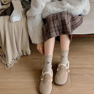 Close-up of wool socks with bow embroidery and warm fleece-lined slippers