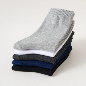Close-up of five pairs of cotton crew socks in grey, white, charcoal, navy, and black