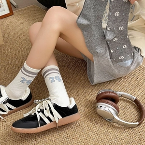 Close-up of white striped crew socks with 24 embroidery and grey letter pattern socks