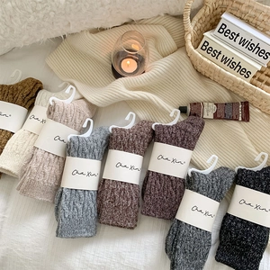 Detailed knit cable pattern on thick winter wool socks in a variety of cozy colors