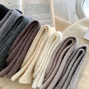 Close-up of thick cable knit wool socks in neutral colors with soft textured finish