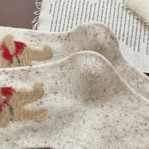 Detail of warm wool blend socks with cute 3D teddy bear embroidery and knit texture