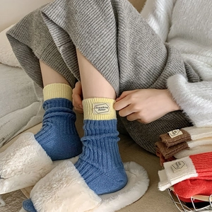 Détail de chaussettes mi-mollet en tricot avec texture rayée et étiquette en tissu