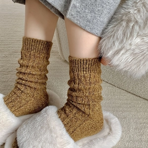 Detail of mustard yellow cable knit thigh high socks with thick ribbed texture for winter
