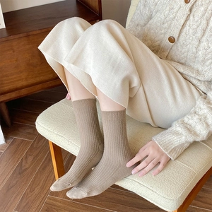 Detailed close-up of light brown ribbed wool socks showing warm knitted texture and cuff