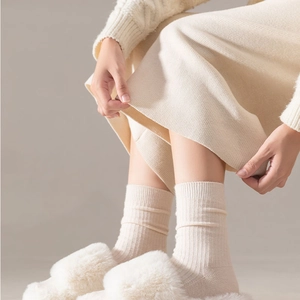 Close-up of beige ribbed wool socks with soft texture and vertical stripe knitting