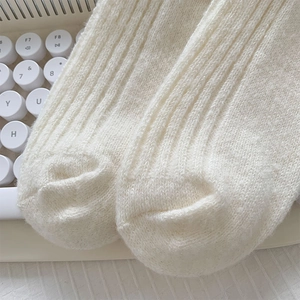 Vue macro des chaussettes en tricot crème avec texture côtelée épaisse et laine mélangée