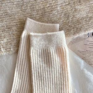 Close-up of beige ribbed wool socks showcasing soft knit texture and warm fabric detail