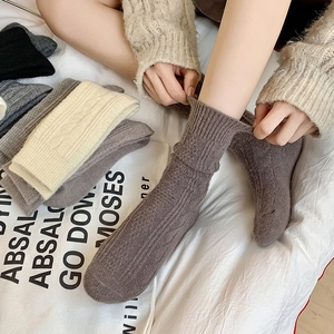 Close-up of cable knit texture on thick wool socks featuring ribbed cuffs for winter