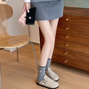 Détail de chaussettes en laine avec broderie nœud et bords festonnés dans un cadre douillet